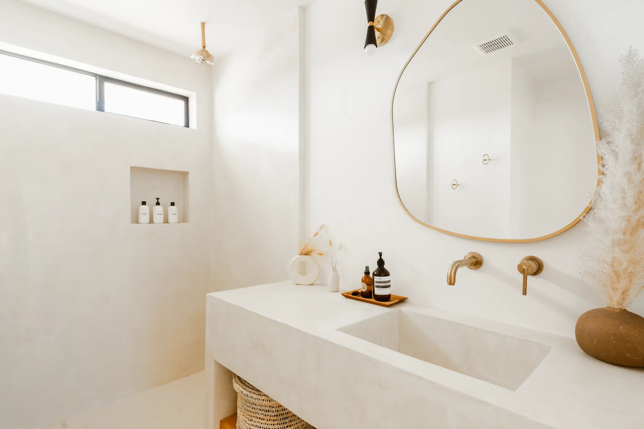 Primary bathroom — bone plaster walls and brass fixtures
