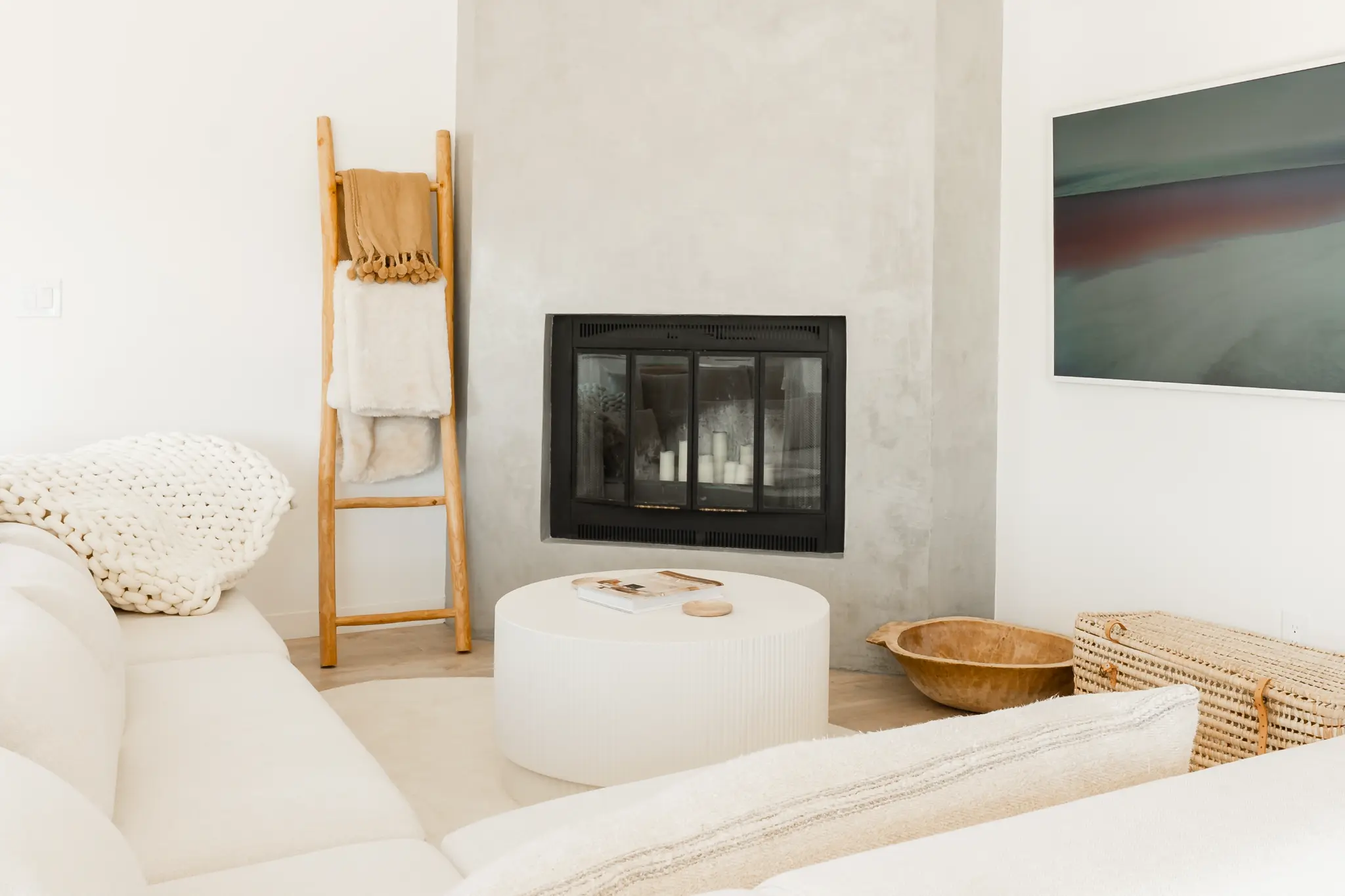 Living room with fireplace, timber beam, and desert light
